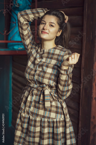 French wear style. How wear checkered dress like fashion girl. Girl, woman with long black hair posing in old cafe background. Fashionable brunette female.