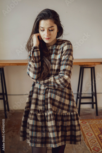 Portrait of a sexual young woman wearing checkered dress. Beautiful smart girl. Beauty, fashion of women wear showroom
