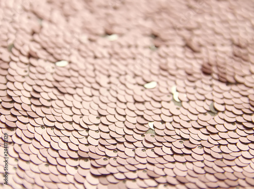 Bright shiny rugged texture of colorful sequins. Fashion fabric background.