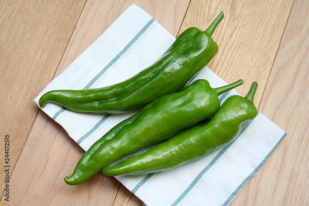 Fresh long green peppers on wooden table. Summer vegetables Fresh long green peppers on wooden table. Summer vegetables