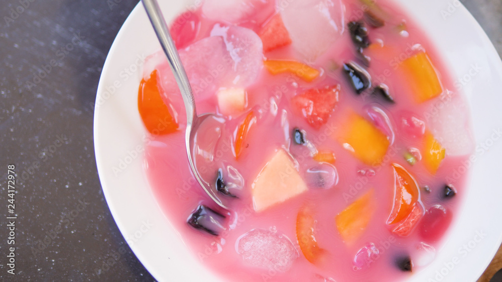 cold fruit soup with slices of tropical fruit and ice. Traditional Asian Indonesian fruit soup dessert. cold fruit soup with slices of tropical fruit and ice. Traditional Asian Indonesian fruit soup dessert.