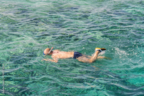 man with snorkel mask tuba and snorkel in sea. Snorkeling, swimming, vacation. Tourists are engaged in snorkeling in the open sea. Holidays in the seaside resort.