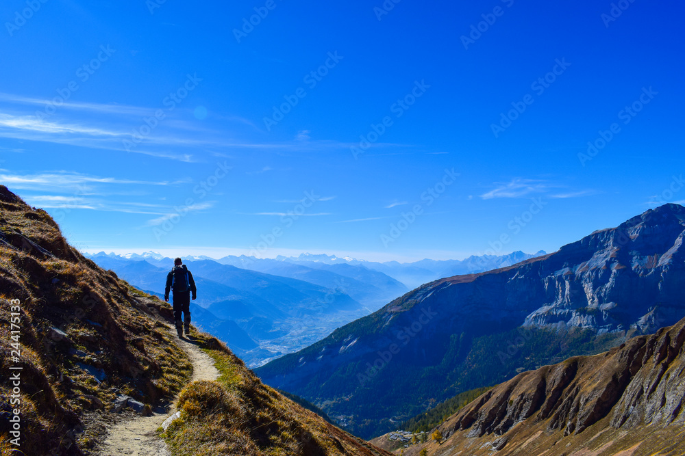 Hiker in the region of Torrenthorn, with a stunning view of the swiss alps, Switzerland/Europe