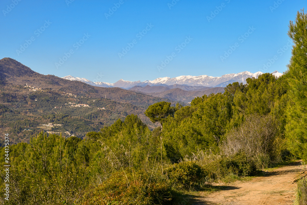 Panoramic view of the Ligurian Apennine mountains with snowcovered peaks from the trail of Capo Mele, Laigueglia, Liguria, Italy