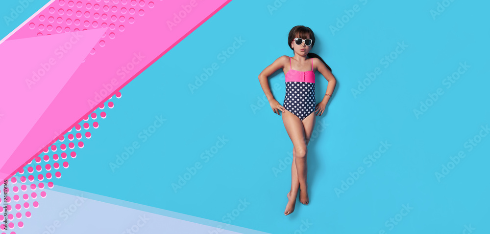 Fashion child summer. Little girl kid in swimsuit lay view top. Concept beach vacation. Blank, banner, copy space for ,advertising. Isolated pink, blue color background like sea water in studio. - obrazy, fototapety, plakaty 