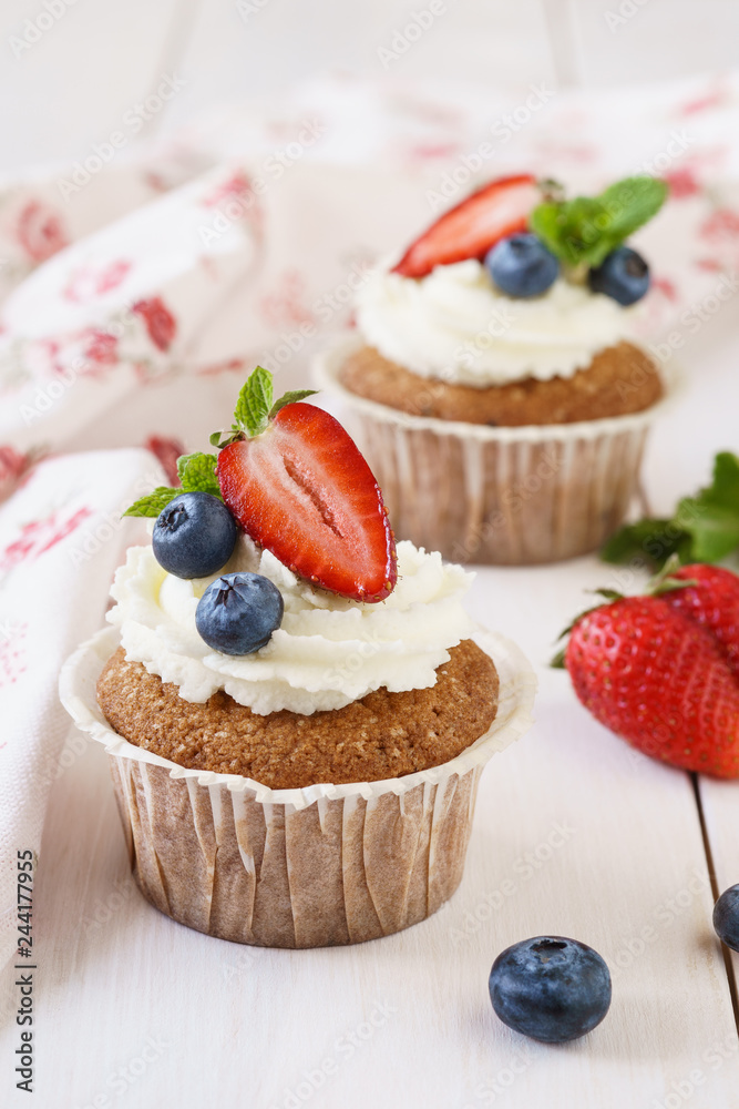 Vanilla cupcakes decorated with fresh mint and berries.