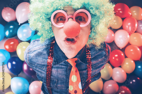 Mann in Karnevalsstimmung auf buntem Hintergrund aus Lüftballons.party Konzept
