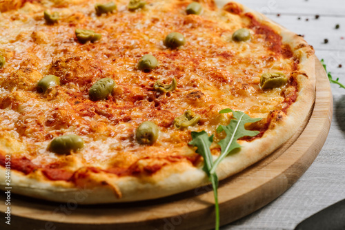 Tasty fresh pizza Margarita with mozzarella and olives on the white wooden background