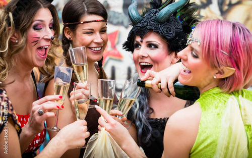 Gruppe von Frauen im Karneval gönnt sich Glas Prosecco am Rosenmontag