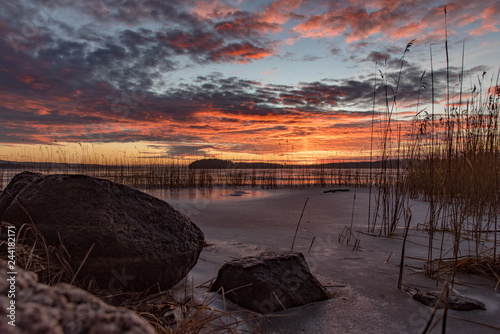 Orange sunset over frozen lake in Sweden photo