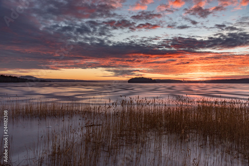 Orange sunset over frozen lake in Sweden