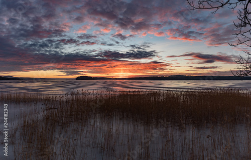 Orange sunset over frozen lake in Sweden photo