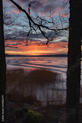 Orange sunset over frozen lake in Sweden photo