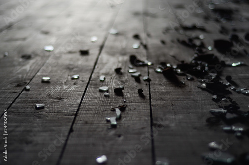 Small shards of glass on the dark wooden floor