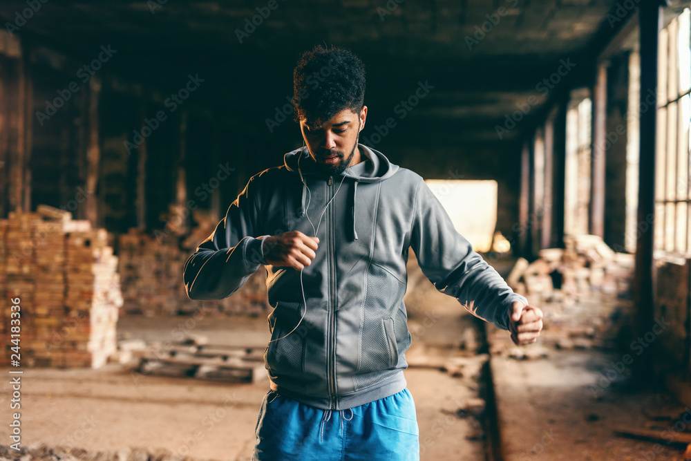 Portrait of african american guy in sportswear working out in old brick factory. Healthy lifestyle concept. - obrazy, fototapety, plakaty 