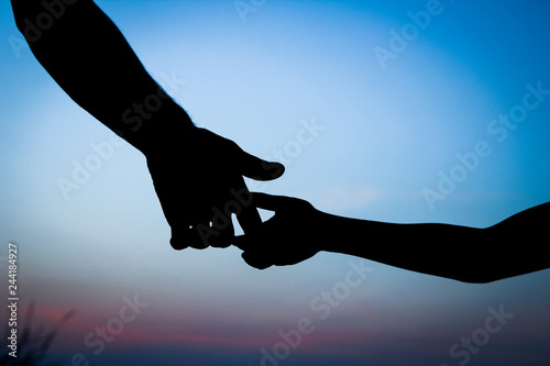 happy parent father with baby hand silhouette at sunset in nature park © Kostia