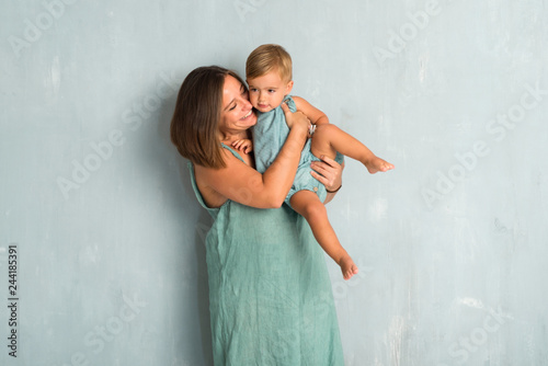 Adorable little baby with his mother on vintage grunge background