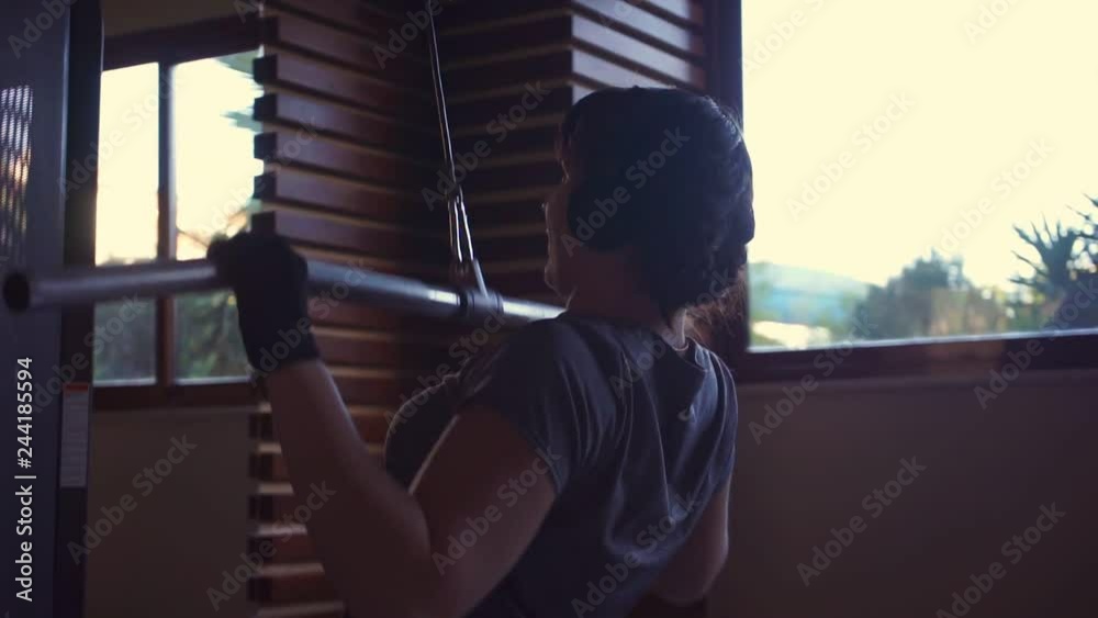 Girl does exercises in simulator on back muscles, then stretches the muscles Girl does exercises in simulator on back muscles, then stretches the muscles