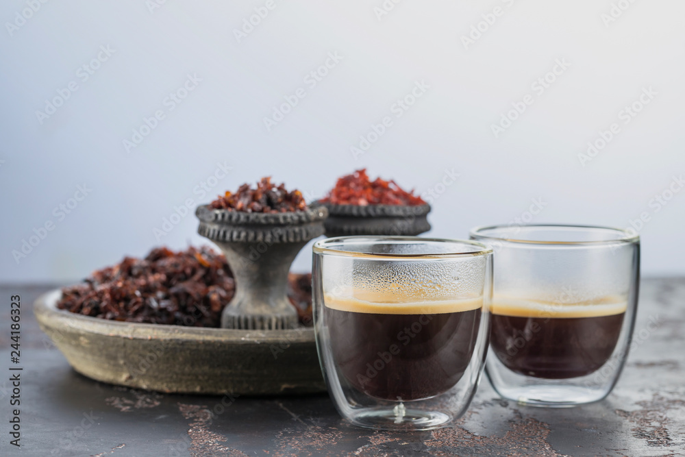 Espresso coffee in small glass cups on the background of ceramic cups for Smoking hookah filled with different types of Shisha Espresso coffee in small glass cups on the background of ceramic cups for Smoking hookah filled with different types of Shisha