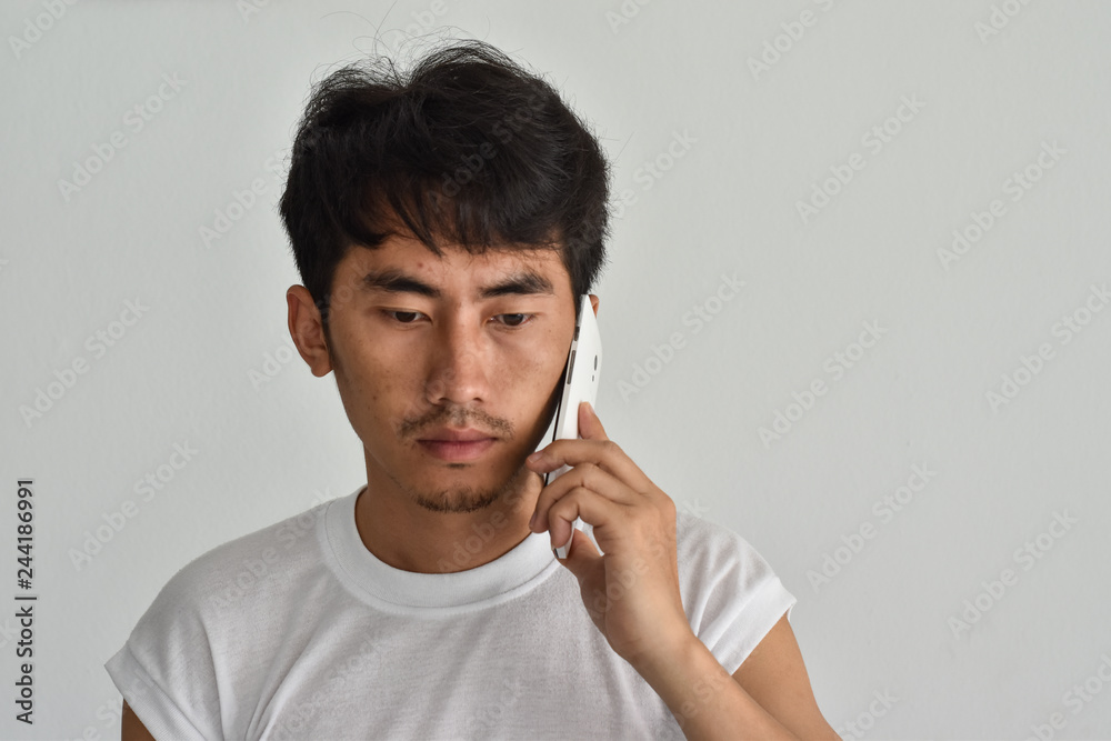 A male is talking on the phone with sad face A male is talking on the phone with sad face