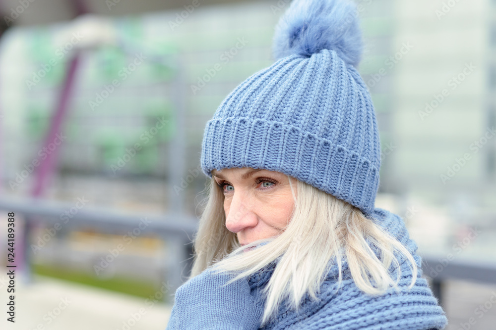 Attractive blond woman snuggling into a warm scarf Attractive blond woman snuggling into a warm scarf