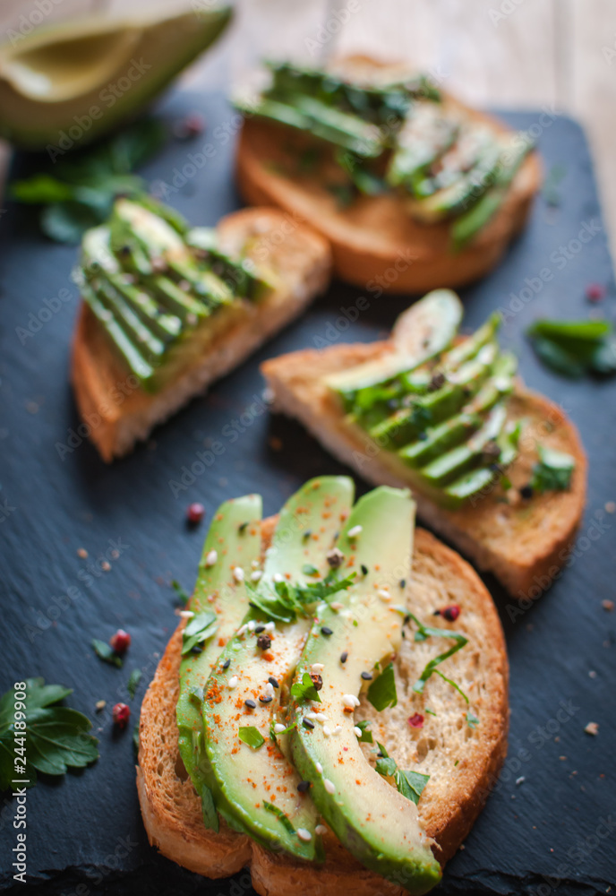 Close-up of fresh avocado toast with spices on dark background Close-up of fresh avocado toast with spices on dark background