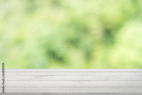 White wood table with green blurry trees background, nature concept.
