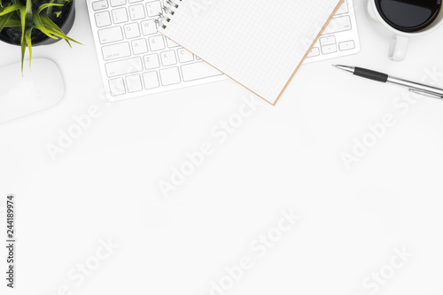 white office desk table with computer keyboard, mouse, cup of coffee and supplies. Top view with copy space, flat lay.