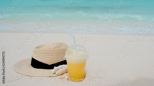 Relax on a tropical island, concept. Protection from sun and heat. Straw hat and pineapple juice