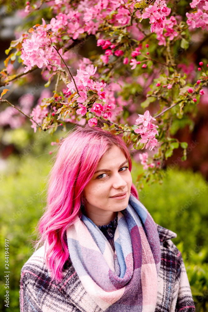 young beautiful girl with pink hair standing near a tree with flowers, pink flowers, spring, sun, happiness young beautiful girl with pink hair standing near a tree with flowers, pink flowers, spring, sun, happiness