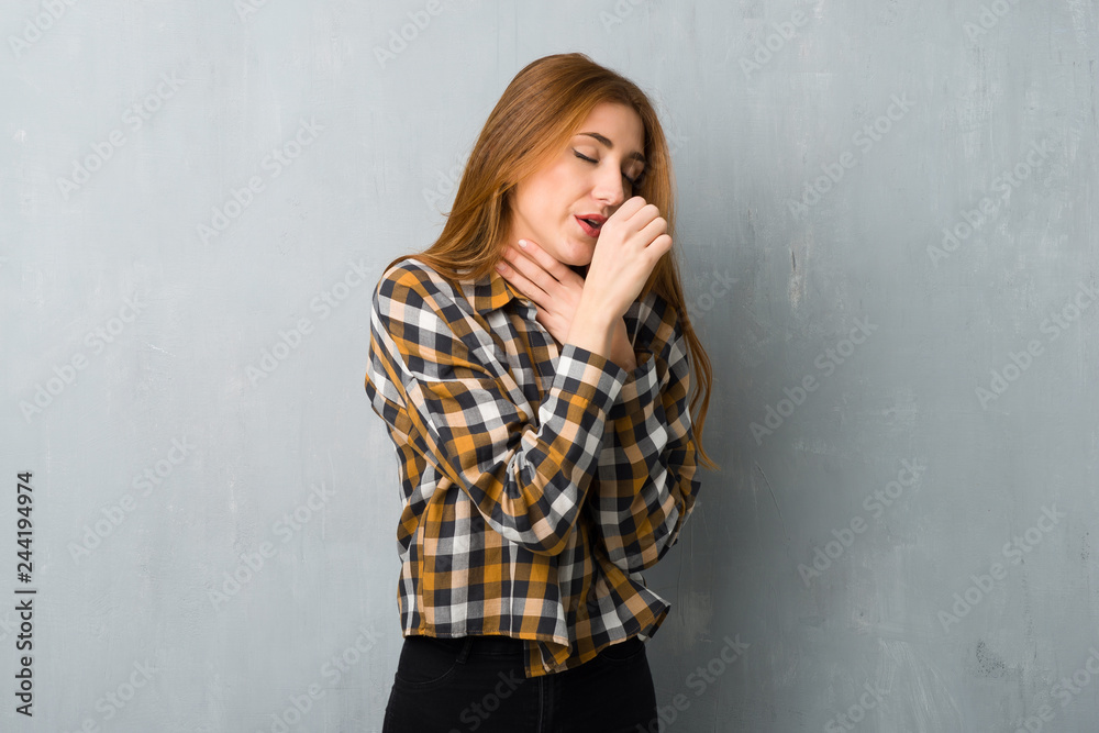 Young redhead girl over grunge wall is suffering with cough and feeling bad Young redhead girl over grunge wall is suffering with cough and feeling bad
