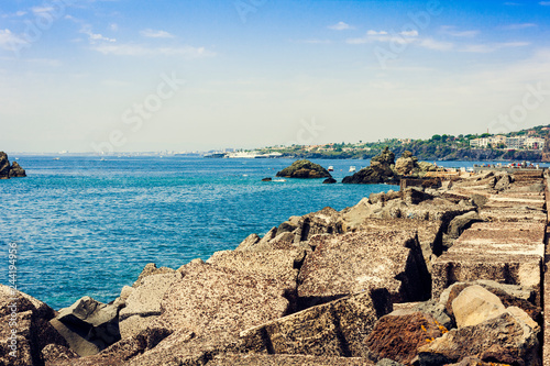 Rocky sea shore of Acitrezza next to Cyclops islands, Catania, Sicily, Italy. © Inna