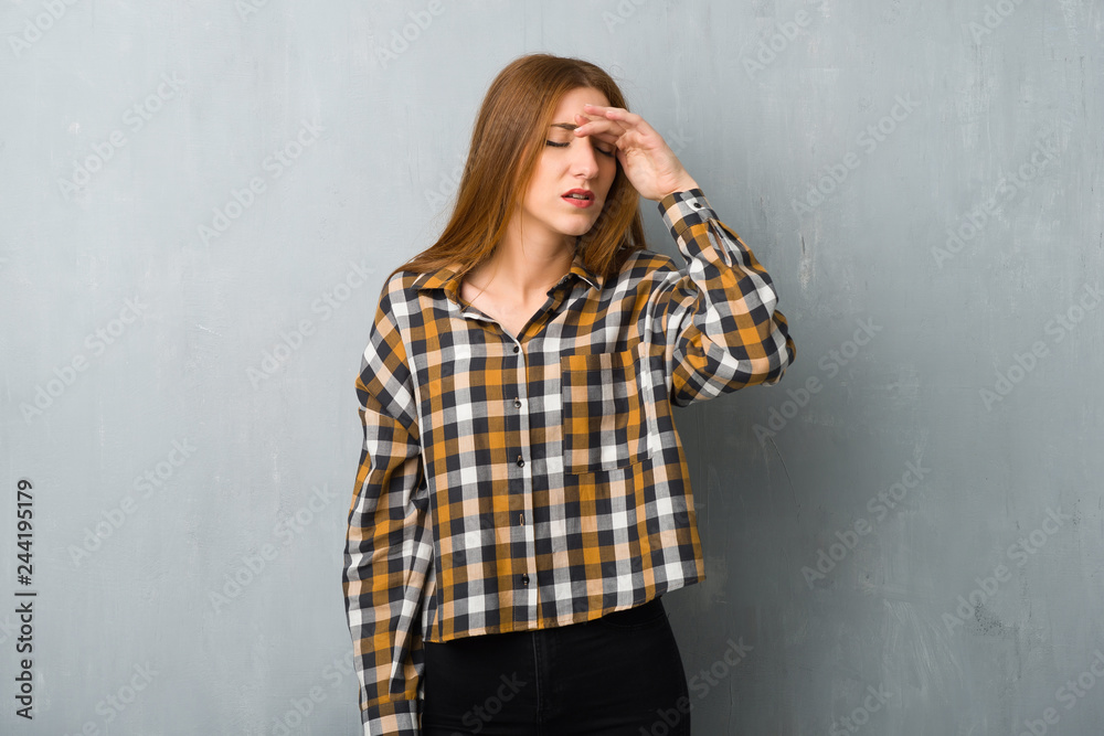 Fototapeta premium Young redhead girl over grunge wall with tired and sick expression