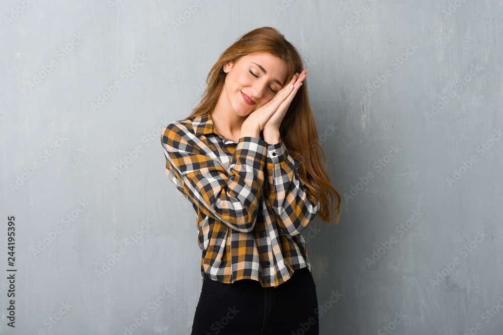Young redhead girl over grunge wall making sleep gesture in dorable expression Young redhead girl over grunge wall making sleep gesture in dorable expression