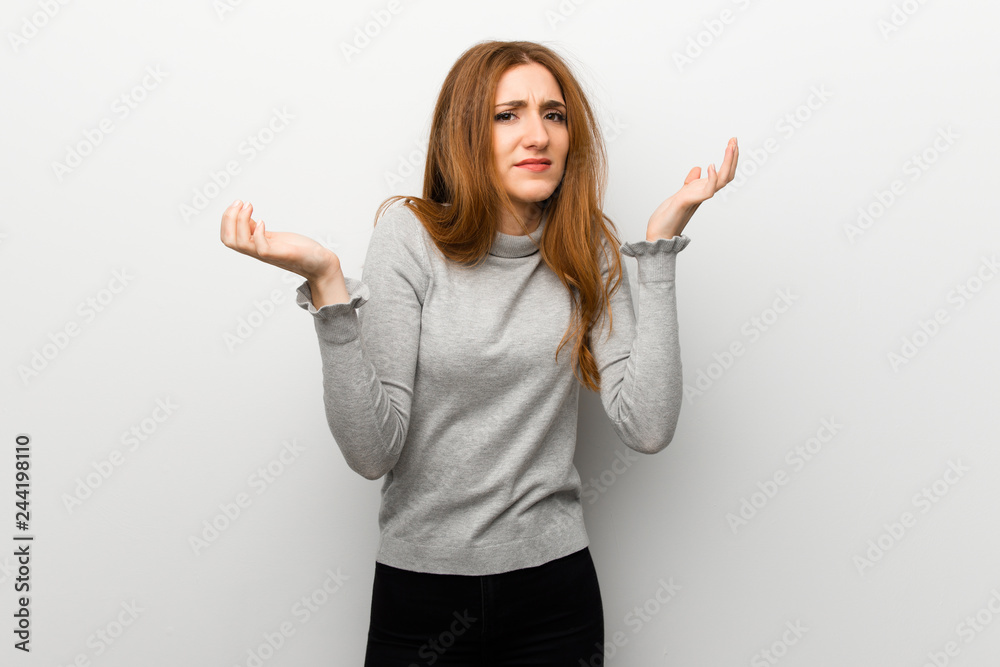 Redhead girl over white wall unhappy and frustrated with something because not understand something Redhead girl over white wall unhappy and frustrated with something because not understand something