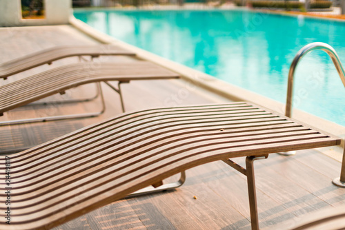 wooden outdoor bench near swimimg pool relax vacation background concept photo