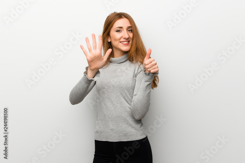 Redhead girl over white wall counting six with fingers © luismolinero