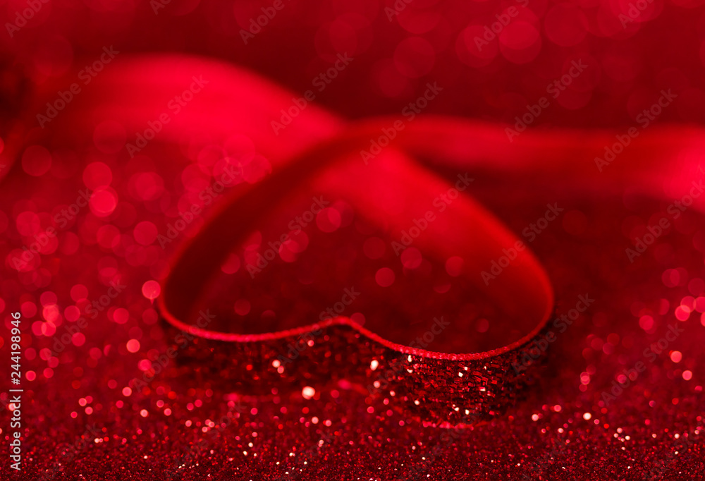 Heart is lined with bright red ribbon on shiny background for Valentine's day Heart is lined with bright red ribbon on shiny background for Valentine's day