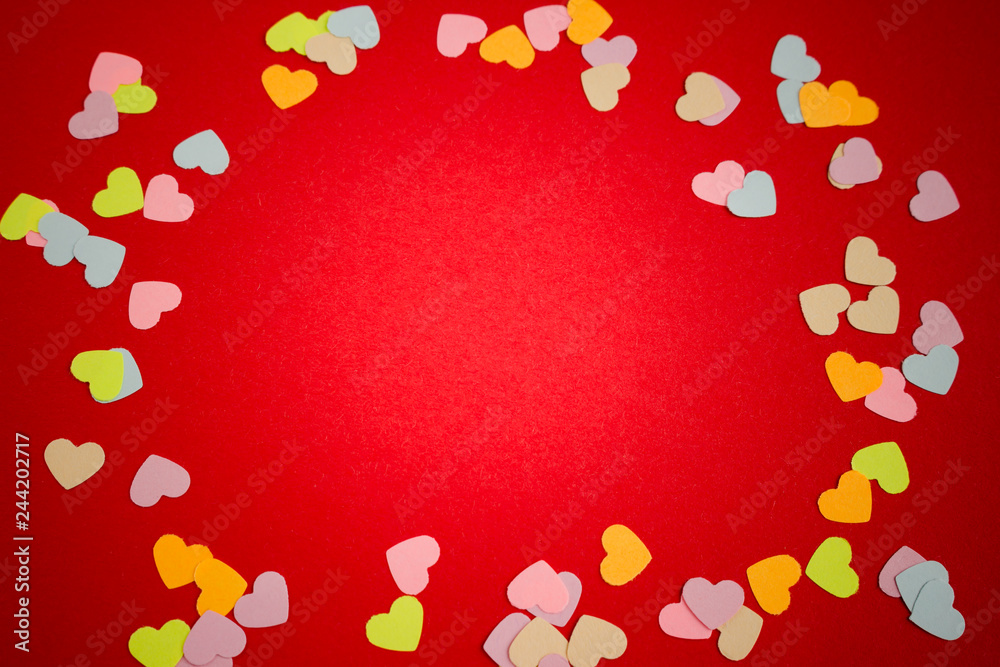 Many white and pink paper heart shaped confetti on red background with copyspace. Valentine's concept card. Many white and pink paper heart shaped confetti on red background with copyspace. Valentine's concept card.