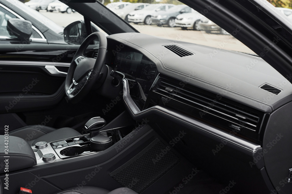 Interior of a prestigious modern black car. Leather comfortable seats and accessories and steering wheel Interior of a prestigious modern black car. Leather comfortable seats and accessories and steering wheel