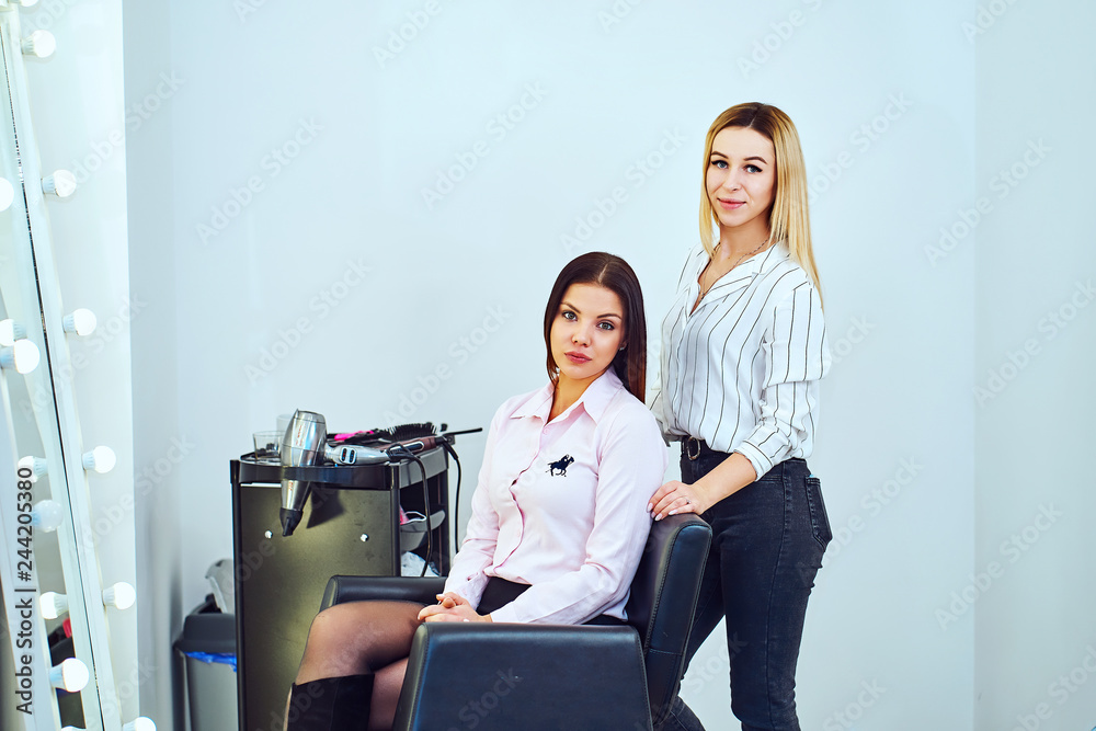 Female hairdresser at the salon holding a hair straightener Female hairdresser at the salon holding a hair straightener