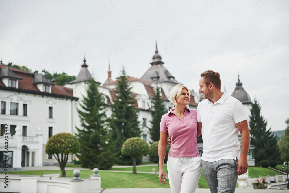 Obraz premium A handsome couple, man and a woman walking together holding hands. The concept of middle-aged relationships