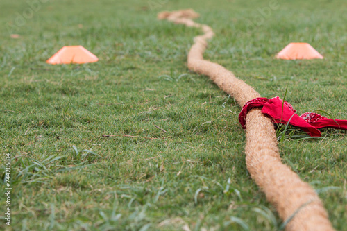 Tug Of War Rope With Bandana Attached Lies On Grass