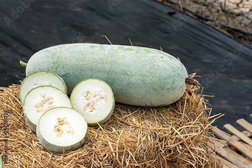 Winter melon is cut into pieces on the straw.