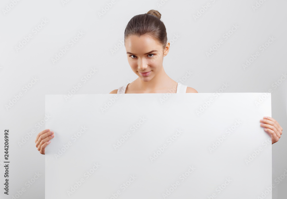 Portrait of a beautiful brunette woman holding a white blank banner. Portrait of a beautiful brunette woman holding a white blank banner.