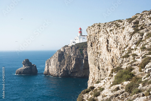 High cliff over the sea with lighthouse on the top in Portugal.