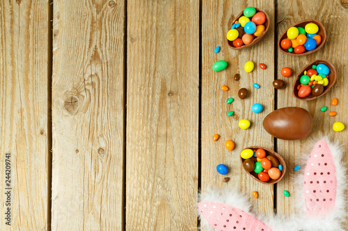 Easter holiday background with chocolate eggs and bunny ears.