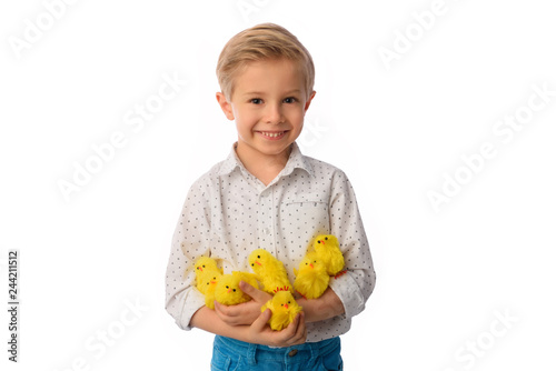 The child is painting eggs for Easter day. Nice, smiling boy sitting at a table with colorful eggs in baskets, yellow chicks. Happy Easter. Isolated on a white.