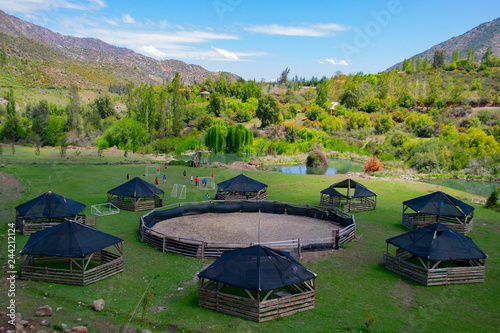 pet pens in circles. closed pens for animals. in the valley between the mountains. animal pens with mountain views. summer. top and side view. in open area © tanyarusa