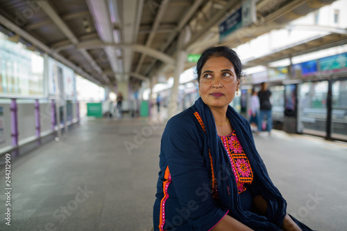 Mature beautiful Indian woman thinking at train station